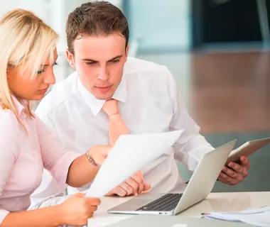 Jednání s klientem nad dokumenty a kalkulačkou při prodeji nemovitosti